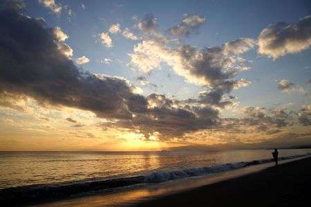 穏やかな冬至の海、夕日と釣り人