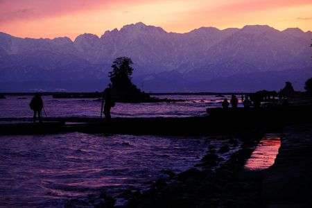 浮き上がる立山連峰の前に広がる朝焼けの雨晴海岸