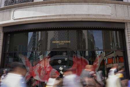 金魚の前で泳ぐ人達