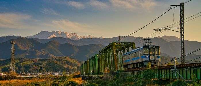 早春　雪化粧の石鎚山と予讃線の列車